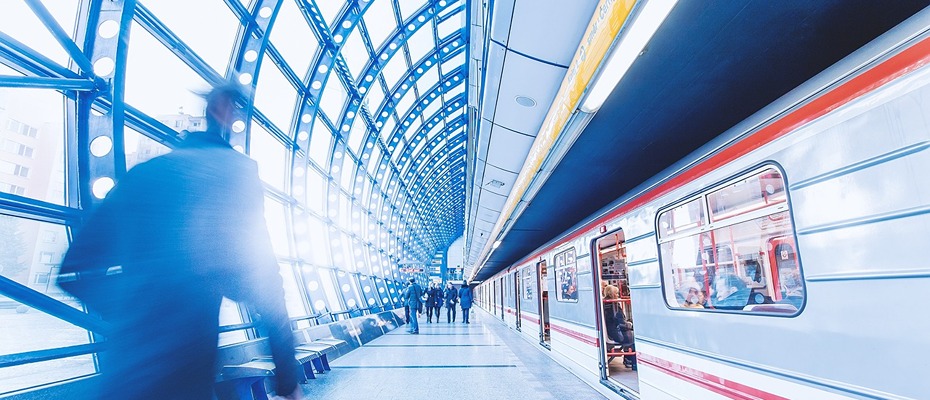 Busy subway station with people and train in motion